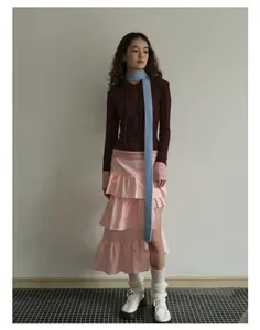 Completo stile retrò con sciarpa in maglia blu e gonna a balze rosa in vista completa