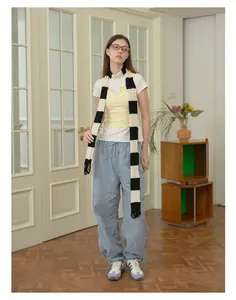 Detail of a chic blue striped knit scarf paired with retro streetwear and cargo pants