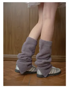 Dettaglio di scaldamuscoli in maglia peluche grigio-viola con texture morbida