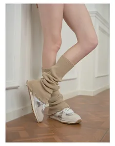 Detail of khaki ribbed knit leg warmers with delicate ruffle edges and slouchy fit