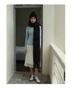 Modell mit schwarzem Grobstrickschal und Beanie zu einem hellblauen Oberteil