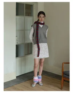 Stile invernale chic con sciarpa di lana a righe colorate e gilet in maglia grigia donna