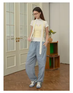 Dettaglio di un set casual da donna con gilet in maglia e joggers celesti con coulisse