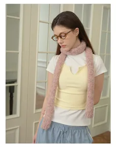 Detail shot of the long pink knit scarf with colorful speckled texture and soft yarn