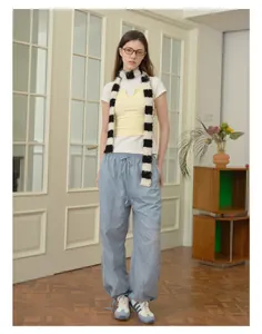 Detail of a fuzzy black and white striped knit scarf paired with a summer casual outfit