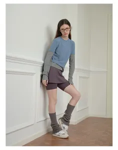 Detail of layered knit leg warmers paired with sports sneakers in a casual home setting