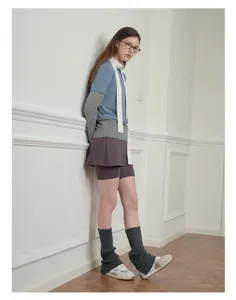Dettaglio di stile di una sciarpa lunga bianca lavorata a maglia con outfit sportivo retrò