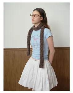Detail showing a dark brown plush skinny scarf paired with a blue bow print t-shirt