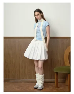 Model showcasing a cream knitted skinny wool blend scarf styled with a light blue tee