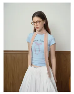 Detail of pink knitted narrow scarf paired with blue bow t-shirt and white pleated skirt
