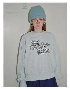 Detail of light blue textured knit beanie hat with striped pattern worn by a female model