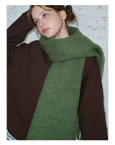 Detailaufnahme des weichen grasgrünen Wollschals getragen zu einem braunen Sweatshirt