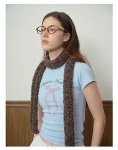 Detail shot of brown thick knit scarf on a model showing cozy boucle texture