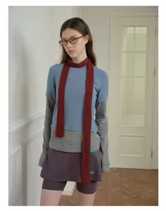 Detail view of burgundy slim knit wool scarf styled with a layered casual outfit