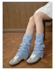 Dettaglio degli scaldamuscoli in peluche blu chiaro abbinati a scarpe da ginnastica