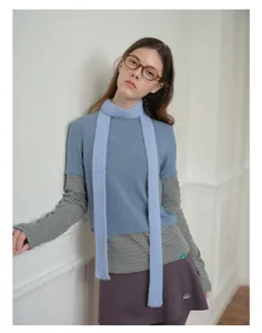 Dettaglio della sciarpa in misto lana azzurra abbinata a un outfit invernale alla moda