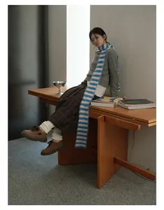 Retro aesthetic outfit featuring a striped knit scarf, grey cable sweater and plaid skirt