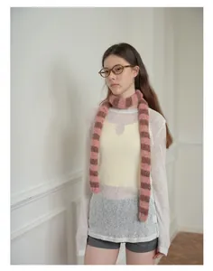 Vista dettagliata di una sciarpa in misto lana a righe rosa e marroni su un outfit alla moda