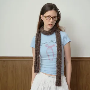 Chic dark brown speckled knit scarf paired with a blue graphic tee and white skirt