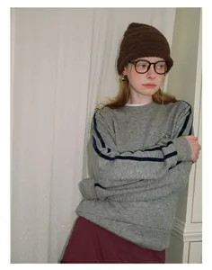 Detail of grey knitted wool beanie with ribbed texture worn with a casual grey sweatshirt