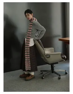Retro striped knit scarf paired with grey cable sweater and plaid pleated skirt