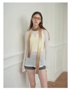 Detail eines braunen Wollmisch-Strickschals mit Farbverlauf kombiniert mit weißem Outfit