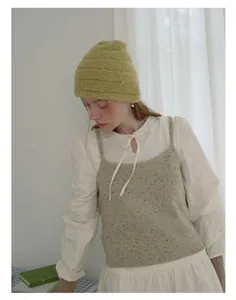 Detail of soft ribbed knit beanie in mustard yellow styled with a minimalist vintage look