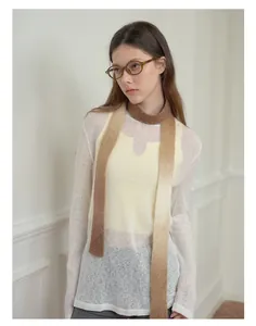 Detail eines schmalen Wollmischschals mit Farbverlauf von Braun zu Beige und Strickpullover