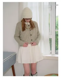 Detailed knit texture of light grey-green wool blend cardigan with minimalist buttons
