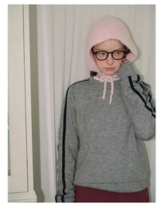 Detail of pink plush knit balaclava hat with ear protection for winter casual outfit