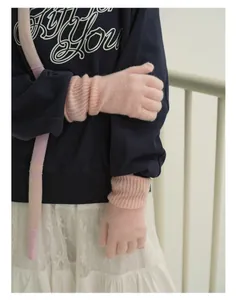 Detailed close-up of soft pink wool knit gloves with elastic ribbed cuffs and warm texture