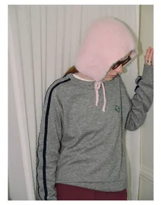 Close-up of pink fluffy knit trapper hat with soft texture and adjustable straps