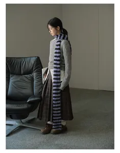 Close-up of extra long faux fur scarf with blue and black stripes in retro style