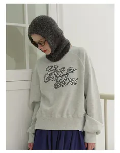 Detail of dark grey textured balaclava hood worn with a casual grey graphic sweatshirt