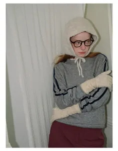 Detail view of cream white plush balaclava hat with integrated ties and soft texture
