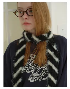 Primo piano di sciarpa in finta pelliccia a righe bianche e nere su outfit di modella
