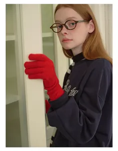Detail of red wool blend knitted gloves featuring warm long ribbed cuffs for winter