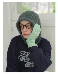 Detail of dark grey wool blend balaclava paired with soft mint green knitted gloves