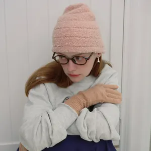 Pink textured wool knit beanie and khaki gloves set for winter warmth on a female model