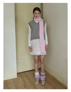 Detail showing bright pink wool scarf with grey knit vest and tweed tassel skirt outfit