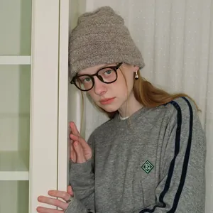 Minimalist grey ribbed knit wool beanie styled with oversized glasses and a casual sweatshirt