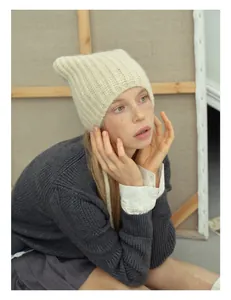 Close-up of soft alpaca wool blend knit cat ear hat in creamy beige with ribbed texture