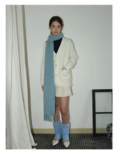 Winter outfit detail showing light blue wool blend scarf with fringe and pleated skirt