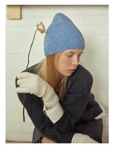 Détail d'un bonnet en laine bleu doux avec gants et pull pour l'hiver chaleureux