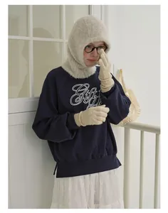 Winter balaclava hat paired with navy sweatshirt and knit gloves for a cozy look