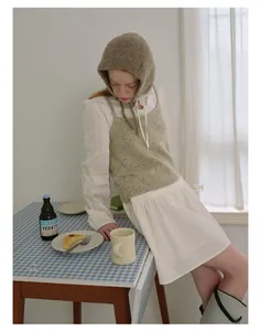 Detailed knit texture of a warm cream-colored French style crochet hood hat for women