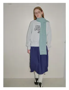 Lookbook-Stil mit mintgrünem Strickschal aus Alpaka-Wolle und grauem Sweatshirt