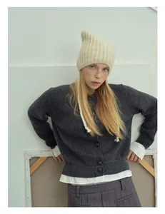 Detailed texture of dark grey alpaca wool blend knit cardigan and cat ear beanie hat