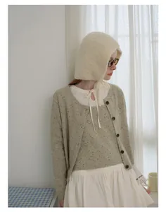 Detail of soft cream knitted beanie featuring a delicate French-style lace-up ribbon design