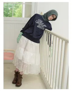 Chic winter style featuring a gray knit balaclava hood with a blue sweatshirt and lace skirt